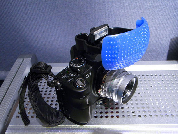 Most flash diffusers are white, but they all serve the same purpose, to diffuse harsh light.  Image courtesy of minami on Flickr.