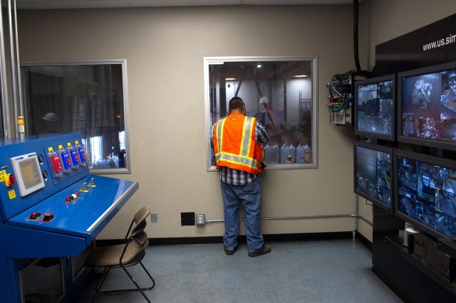 Robert Fragoso, Sims' operations supervisor, looks out a window at the warehouse floor. Monitors on the wall show how things are going on the shredder line. Photo: Jim Merithew/Cult of Mac