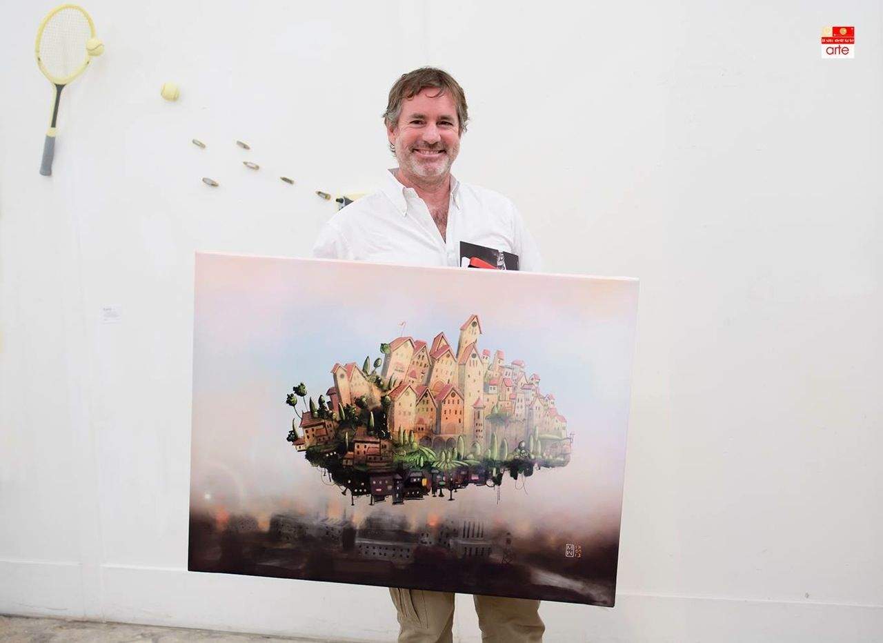 Watkins holds a fingerpainting titled  It's a long way up featured at an exhibit in Verona, Italy.