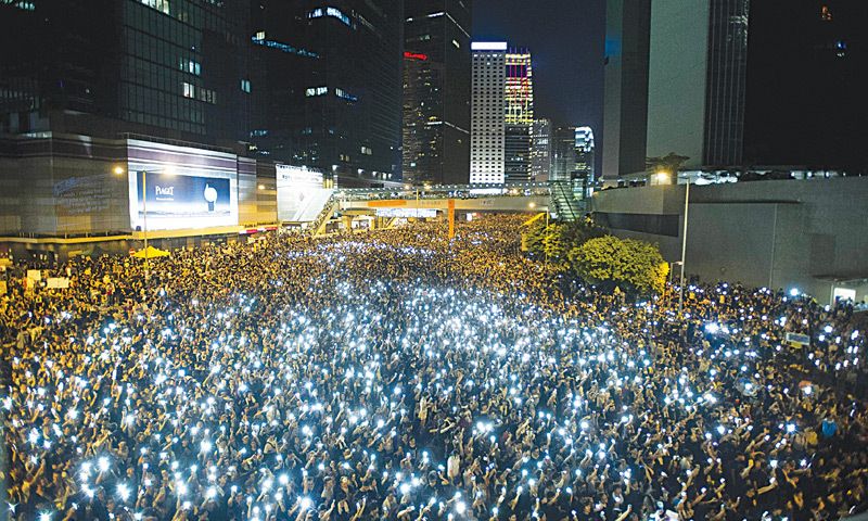 Protesters in Hong Kong hold their phones high. Photo: AFP