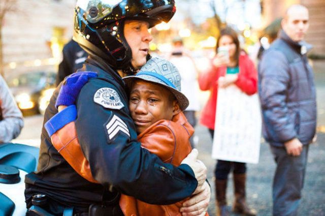 Nov. 25: Portland police Sgt. Bret Barnum, left, and Devonte Hart, 12, hug at a rally in Portland, Ore., where people had gathered in support of the protests in Ferguson, Mo. (Johnny Huu Nguyen/Associated Press)