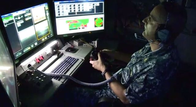 A laser weapons operator aims at a target with the use of hand controller. (U.S. Navy video)