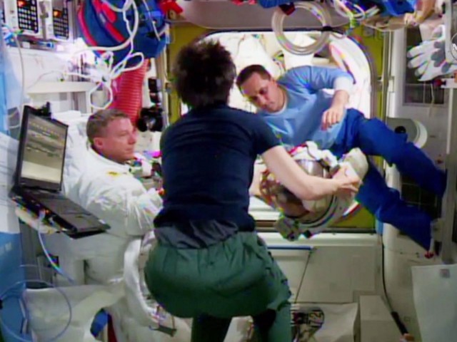 Terry Virts, left, Samantha Cristoforetti and Anton Shkaplerov examine Virts's  helmet after he discovered a small amount of water in it. Photo: NASA TV