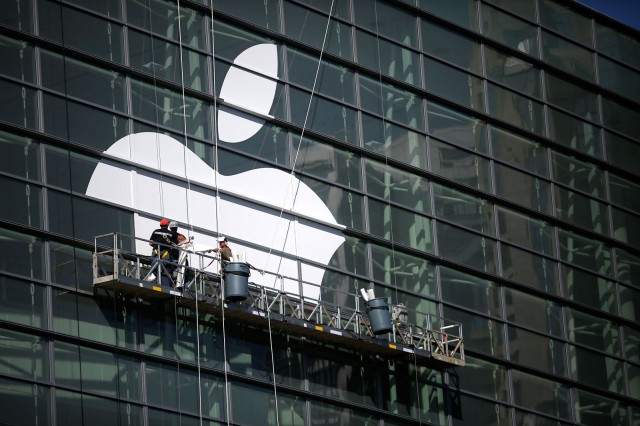 Workers apply a massive Apple logo to Moscone Center's glass wall.