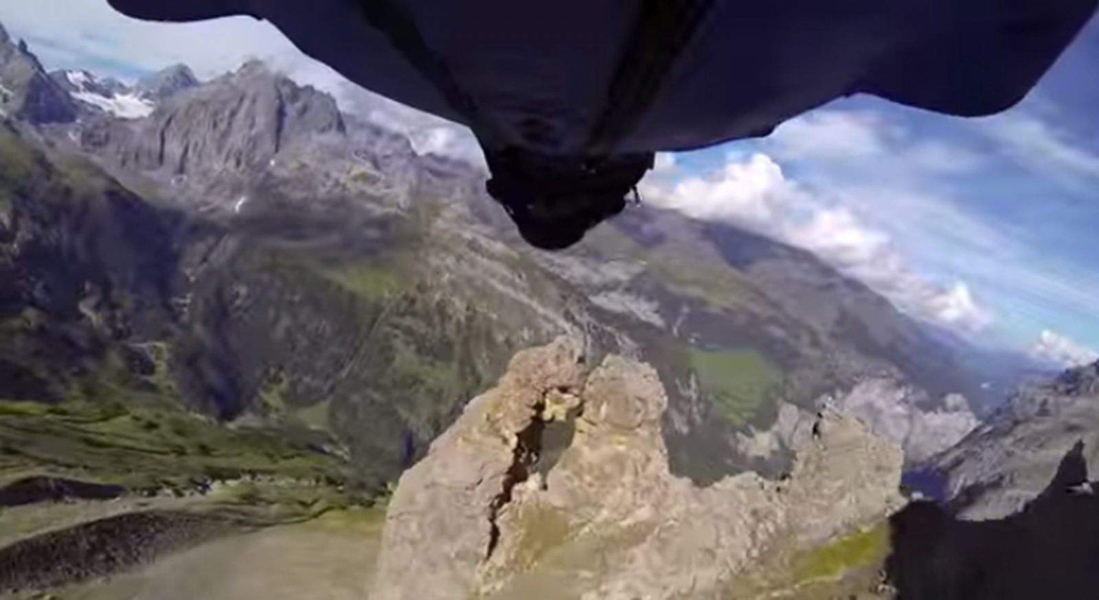 Uli Emanuele aims for the tiny opening of this rock formation in Switzerland.