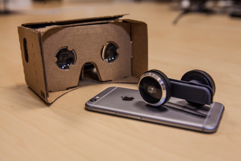 The Shot lens attachment for iPhone with a cardboard headset for enhanced viewing of virtual reality content.