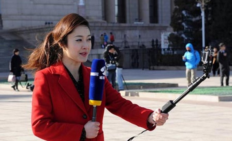 This reporter's microphone windscreen is bulkier than the iPhone she is using to broadcast live.