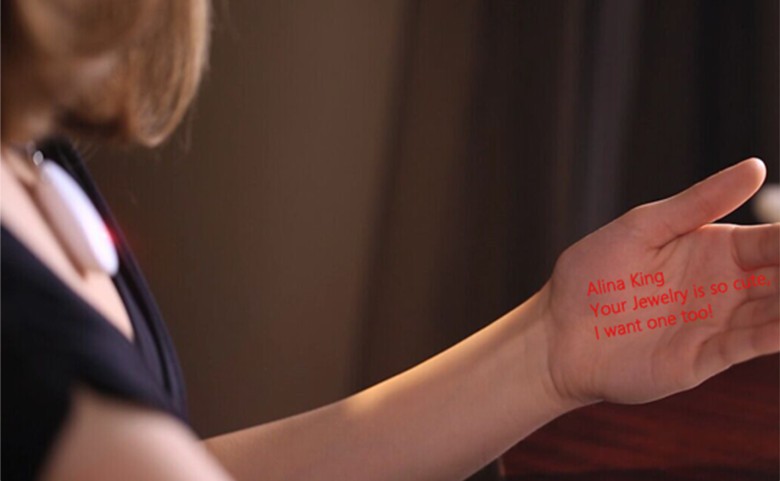 The wearer can read text messages on their hand that come from a micro projector located in the pendant. 