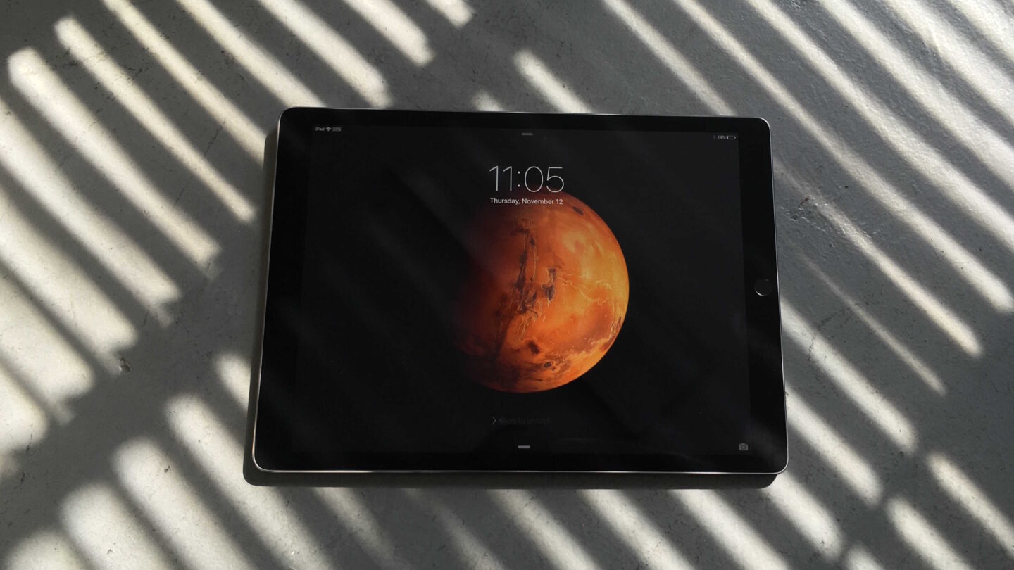 Photo of the iPad Pro lying on the ground with amid shadows from window blinds.