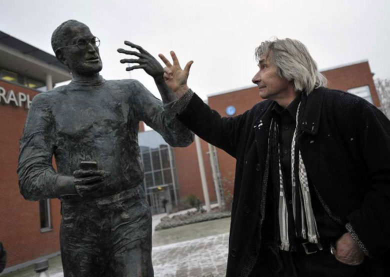 Artist Tóth Ernö, right, gestures with his bronze creation of Jobs.