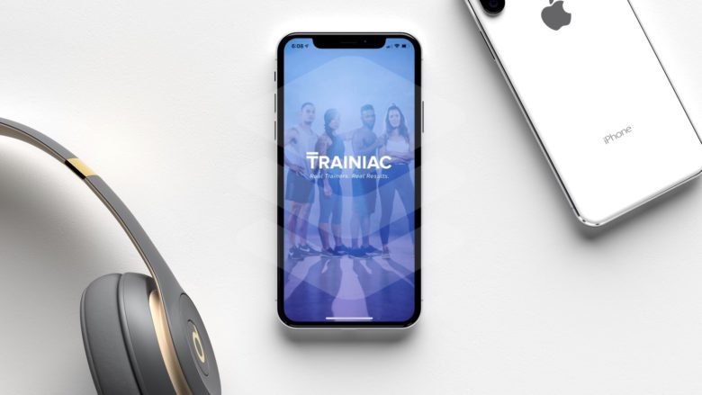 Trainiac fitness app on an iPhone X with Beats headphones.