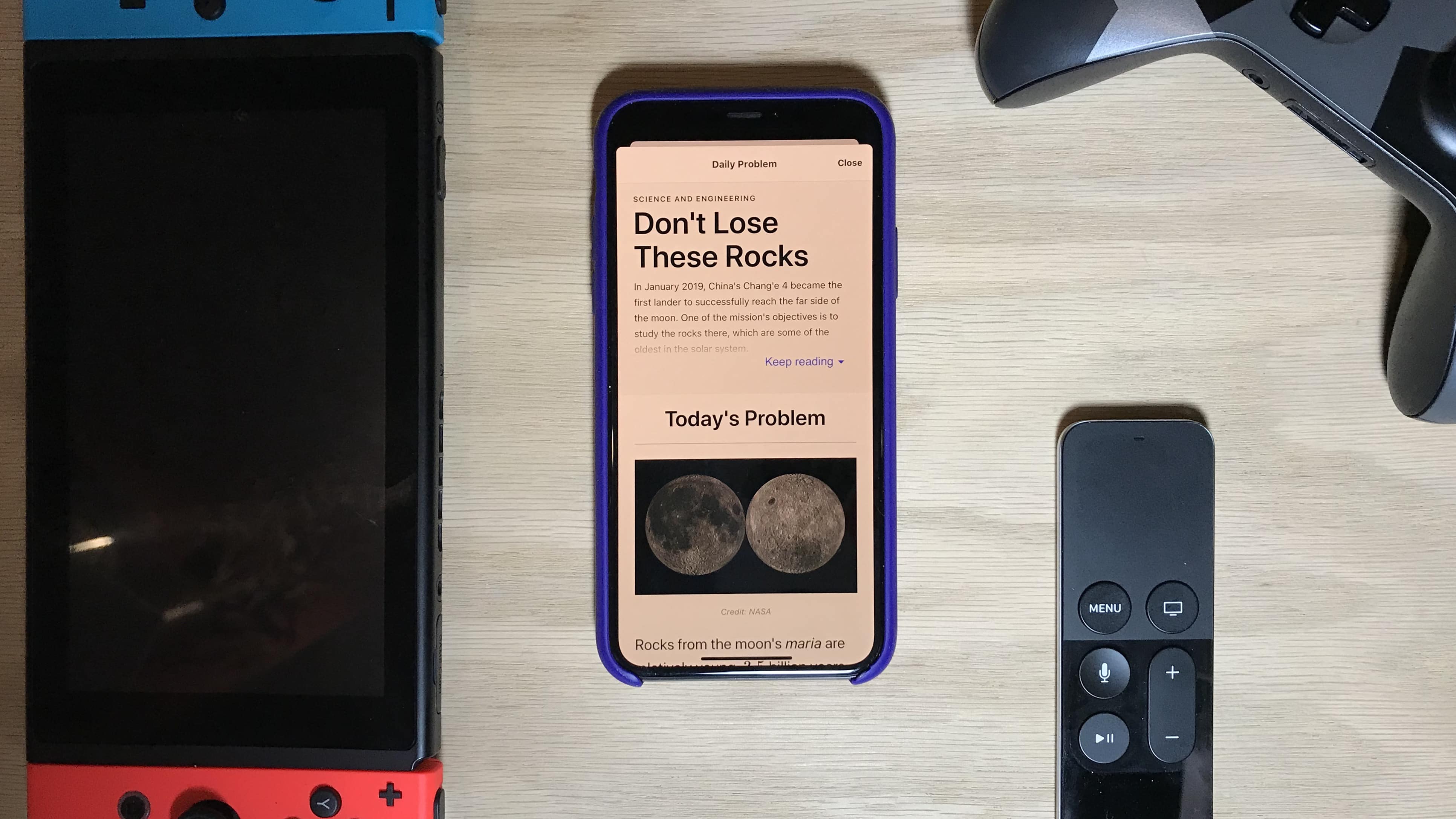 Brilliant iOS app on desk with switch and tv remote