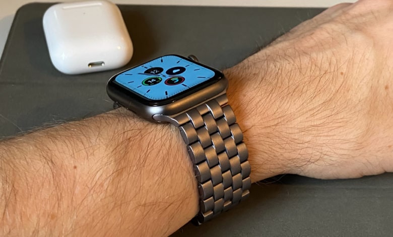 Juuk Qrono, the best aluminum Apple Watch band, as see on a wrist with AirPods nearby.