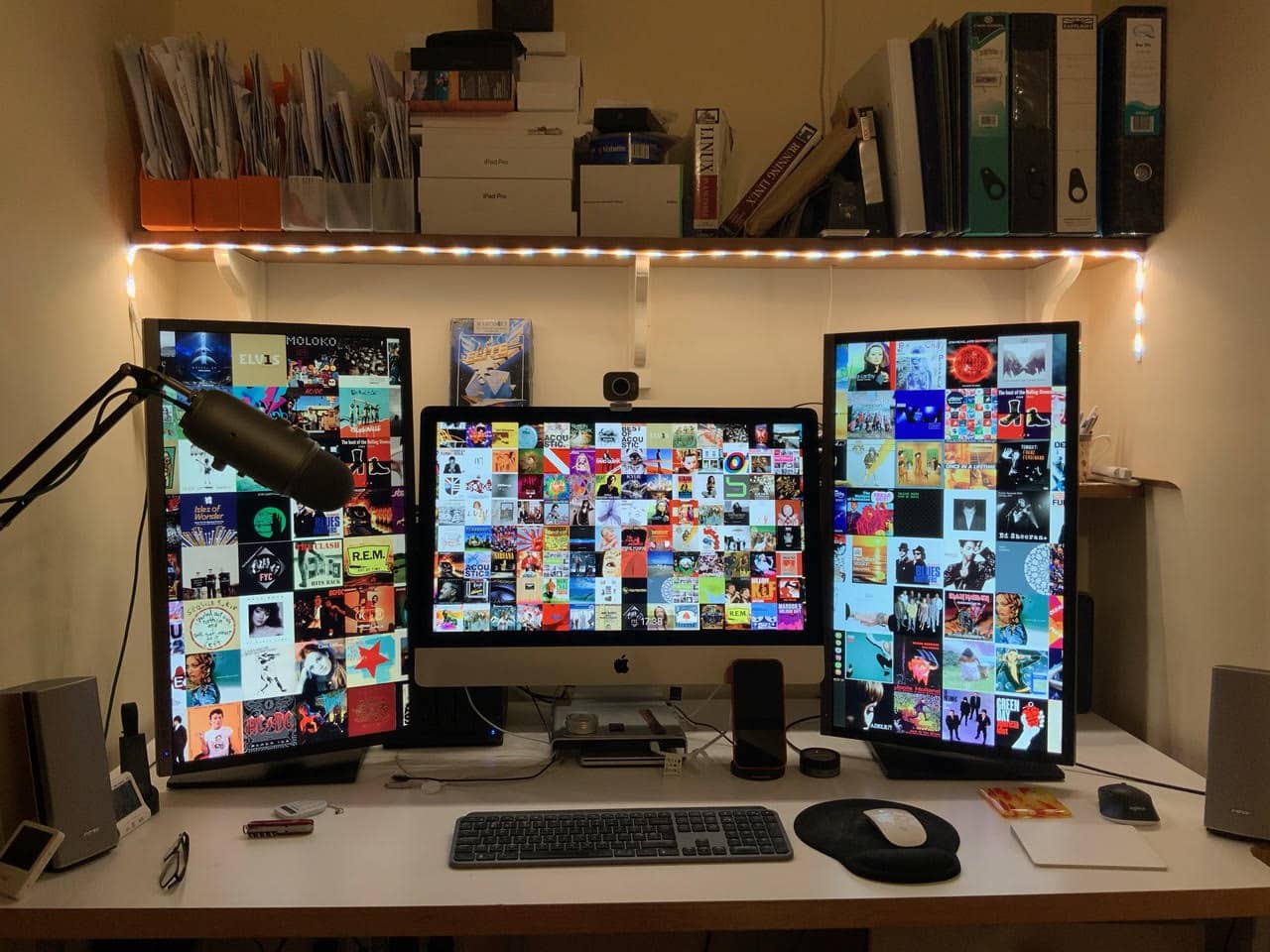 Wilcox's setup centers on a 27-inch 5K iMac with 28-inch Samsung monitors on either side of it.