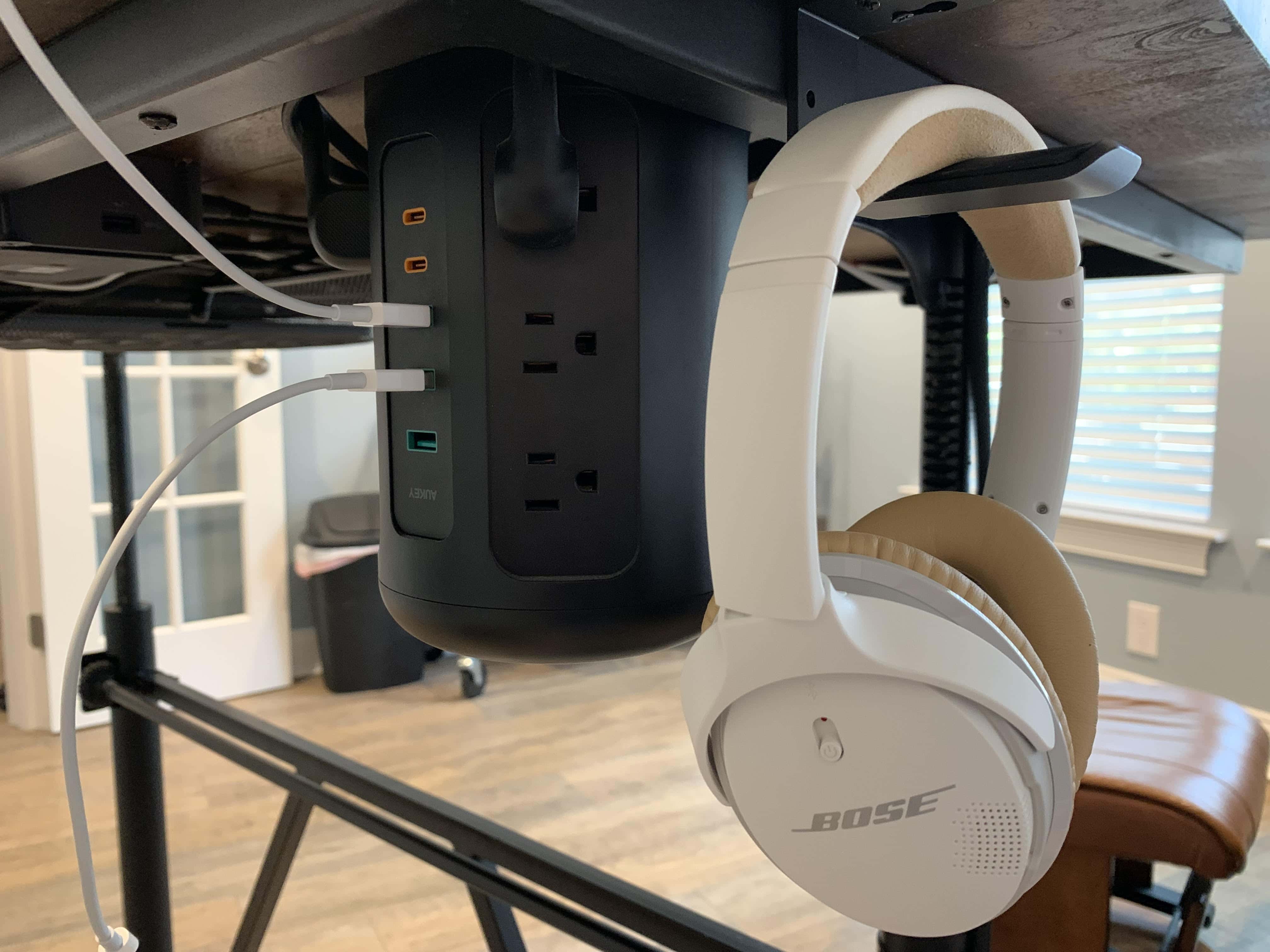 An Aukey power strip tower and headphone hook under the desk also help keep things neat and tidy.