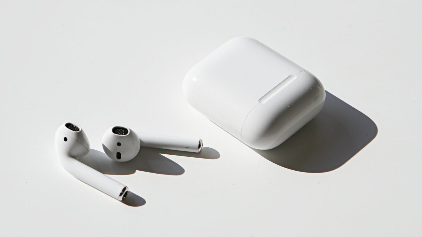 Product photo of original AirPods outside their case to illustrate a "Today in Apple history" post about the first AirPods' launch.