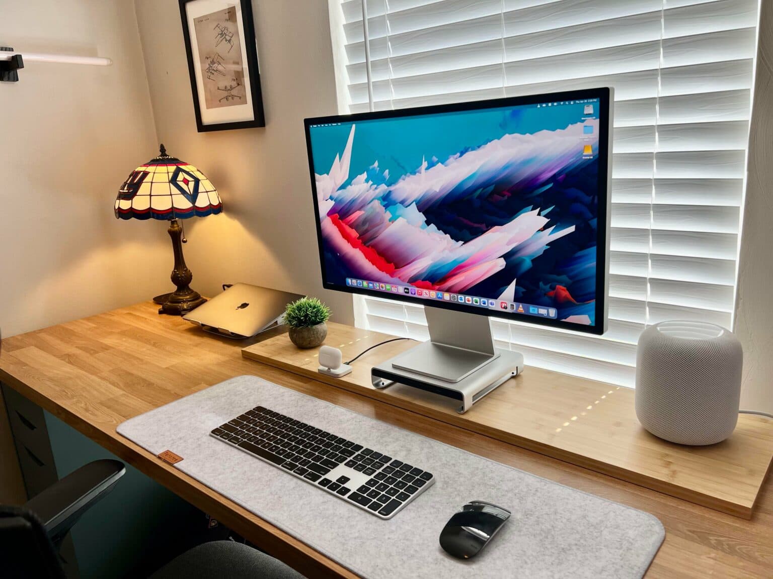 The Studio Display now has silver-and-black peripherals and a MacBook Pro rather than a Mac mini.