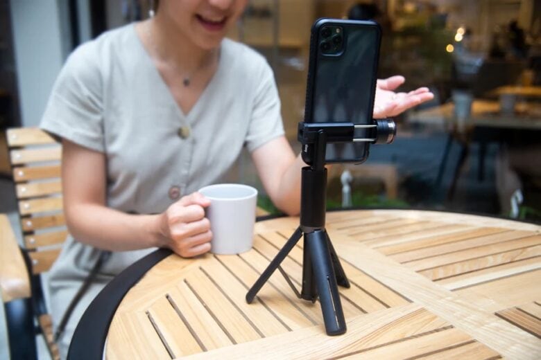 Person on a FaceTime call with iPhone mounted in EasySelfie standing on a table