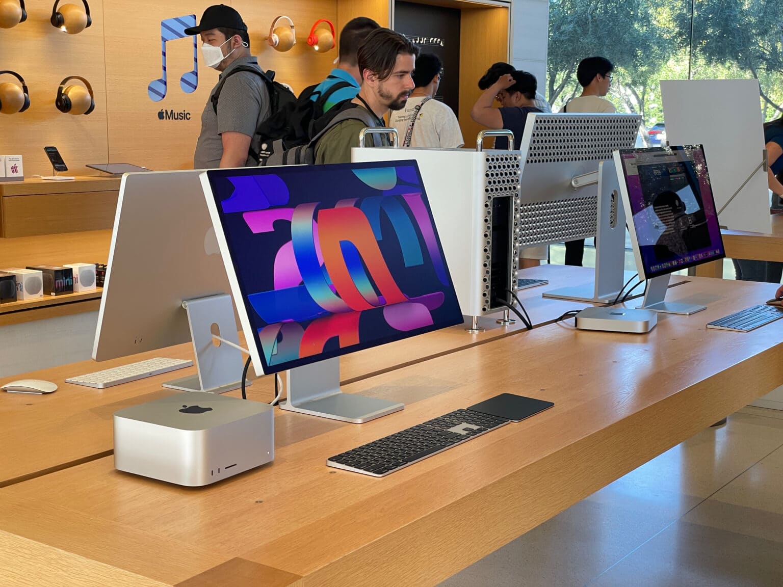 A table of desktop Macs. Going clockwise around the table, starting at the front: the Mac Studio with Studio Display (height-adjustable stand and nano texture glass), the iMac, Mac Pro with Pro Display XDR (with Pro Stand) and Mac mini with Studio Display (tilt stand).