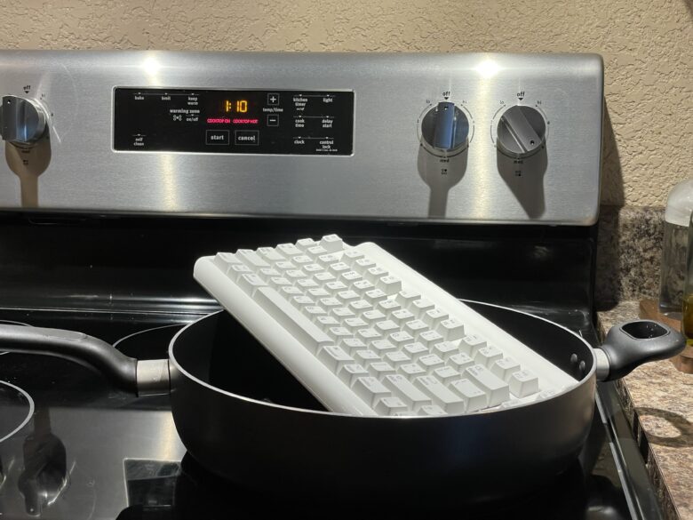 The Matias keyboard sitting in a hot pan on an induction stove top.