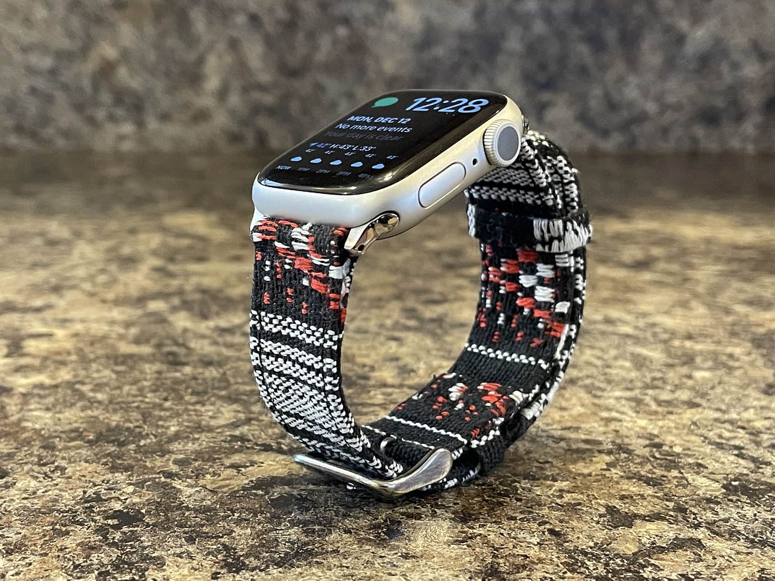 Silver aluminum Apple Watch Series 7 with the black, white and red Stark Nyloon band.