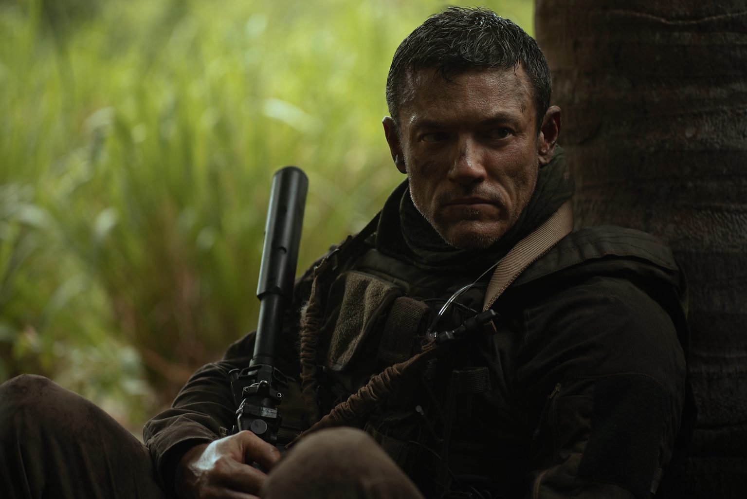 Actor Luke Evans holds a rifle in 