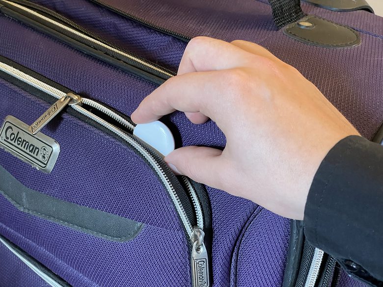 Putting an AirTag into the outer pocket of a bag
