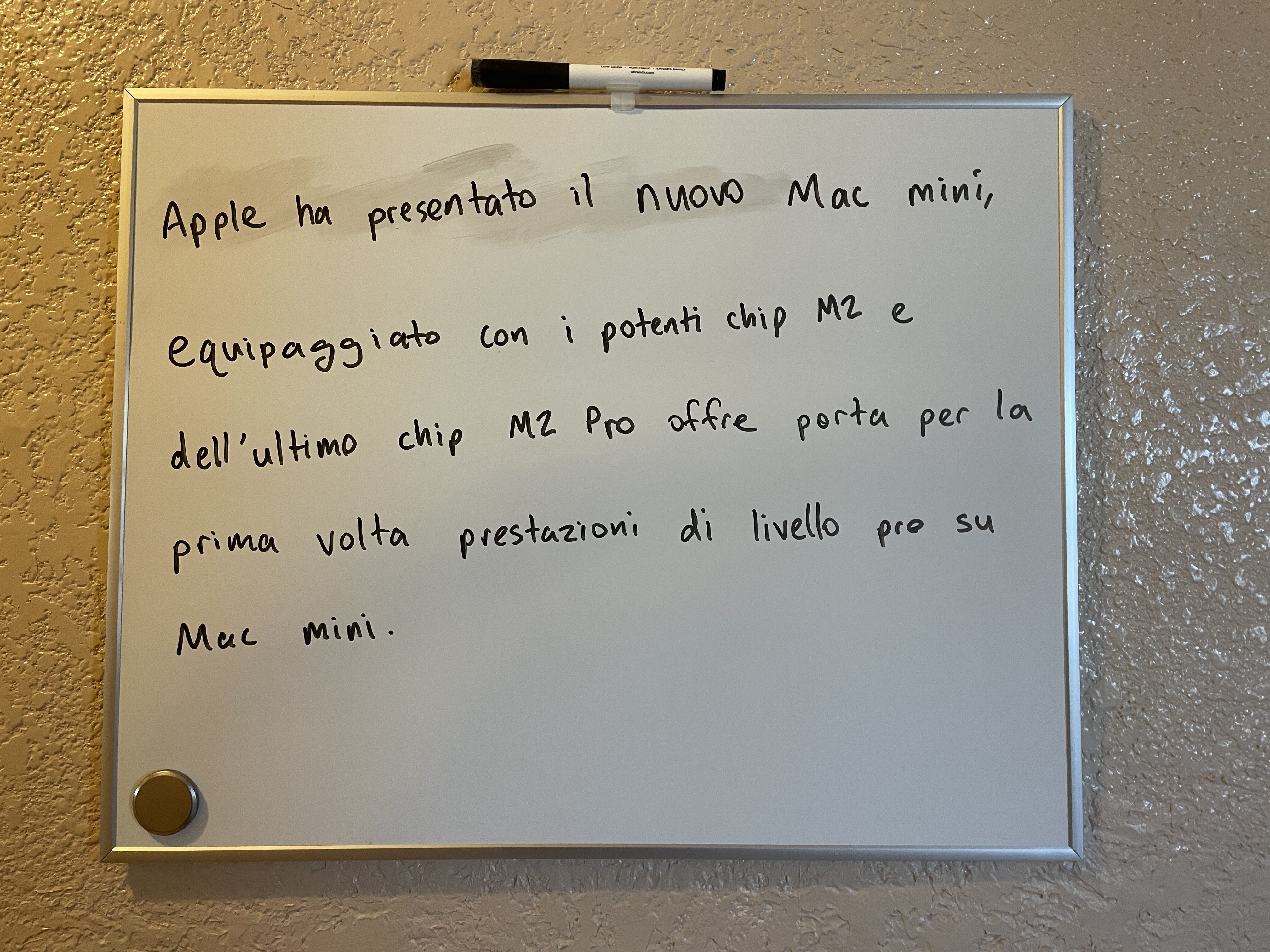 Handwriting on a white board: “Apple ha presentato il nuovo Mac mini, equipaggiato con i potenti chip M2 e dell’ultimo chip M2 Pro porta per la prima volta prestazioni di livello pro su Mac mini.”