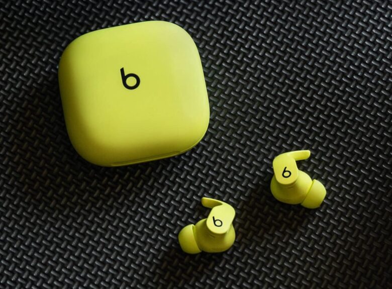 Beats Fit Pro earbuds in Volt yellow with their charging case