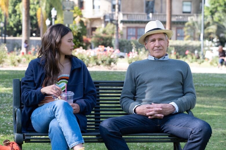 Lukita Maxwell and Harrison Ford sit on a park bench in a scene from Apple TV+ comedy "Shrinking."