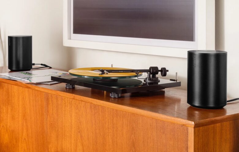 A pair of Sonos Era 100 smart speakers is shown connected via line-in to a turntable.