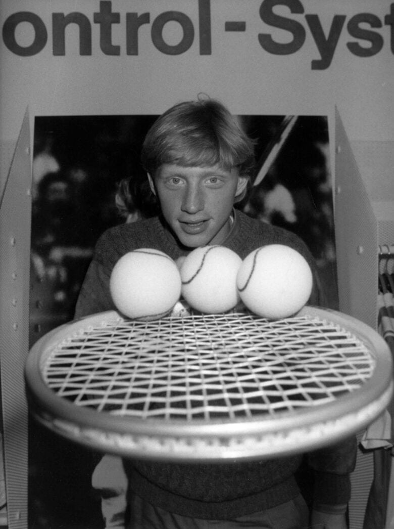 Tennis champ Boris Becker with a tennis racket and three tennis balls in an archival shot from sports docuseries "Boom! Boom! The World vs. Boris Becker," premiering April 7, 2023 on Apple TV+.