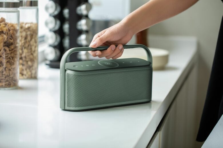 The new speaker has a stainless steel grille and an aluminum handle.