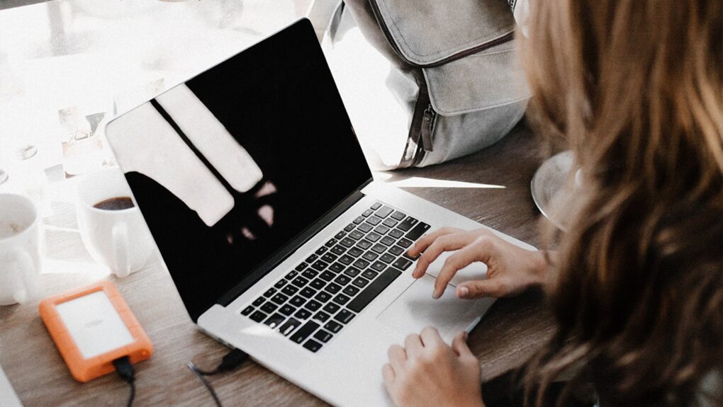 Photo of a woman using a laptop to find cheap flights with Matt’s Flights.