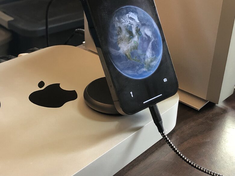iPhone mounted on SwitchEasy Orbit plugged in, sitting on top of Mac mini to leave enough room for the cable
