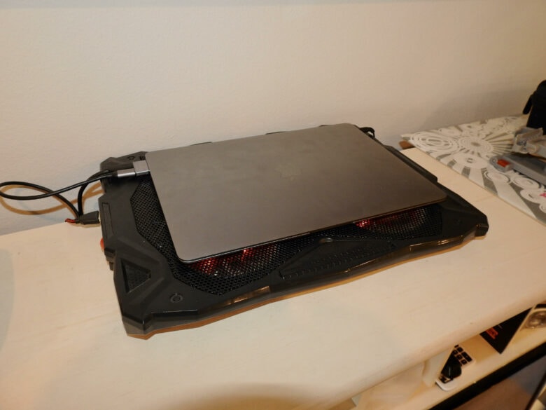 The MacBook Air sits on a cooling pad to dissipate heat.