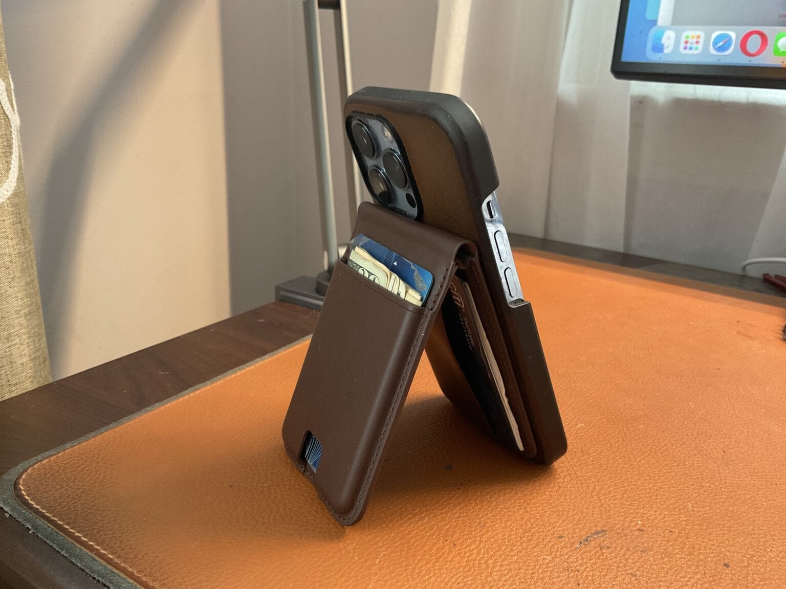 Here's the Ezmo, laden with cash and cards, serving as an iPhone stand. You can widen the stand's angle and mount the iPhone in landscape orientation, too.