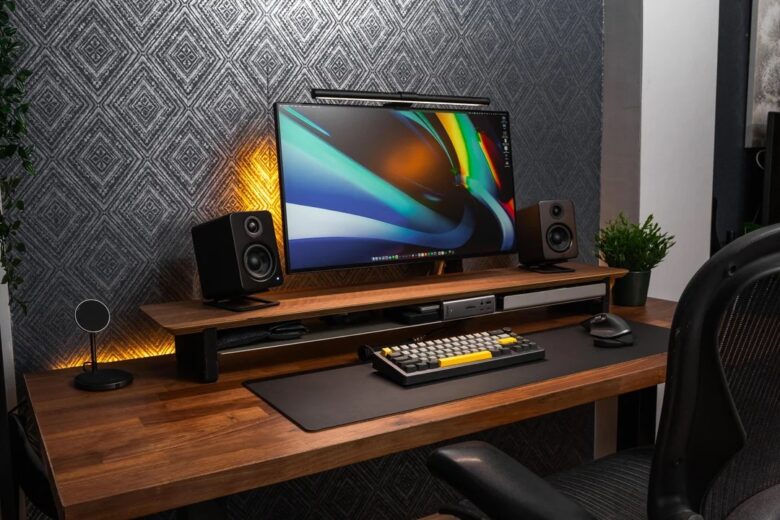 With the MacBook Pro and custom PC on shelves to the left, the desk doesn't get too crowded.