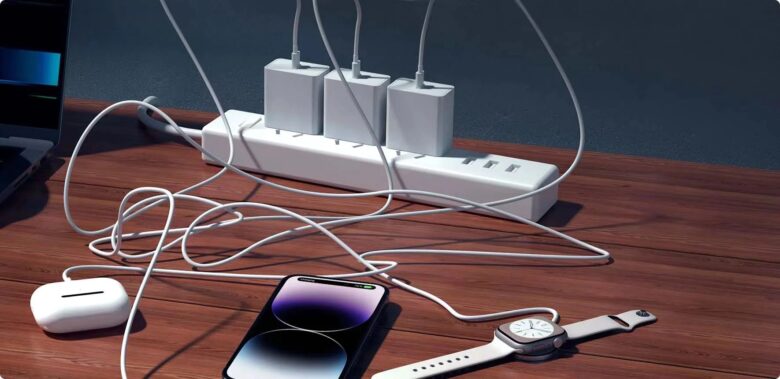 A mess of three charging cables for three devices at a power strip.