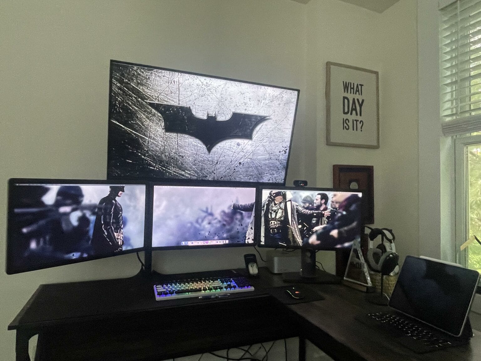 The Bat-Signal is displayed on a giant screen atop three other monitors in a Batman-themed computer setup.