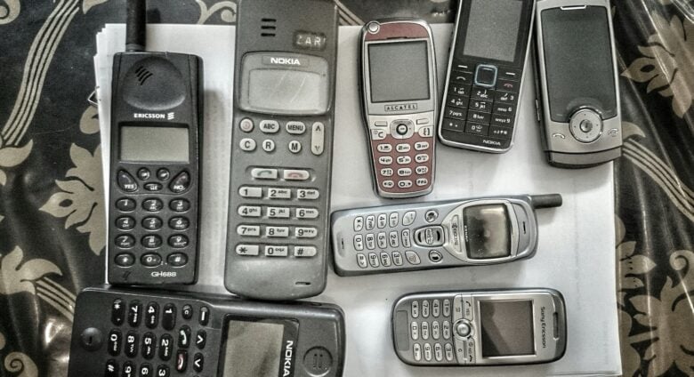 A selection of old phones laid out on a table