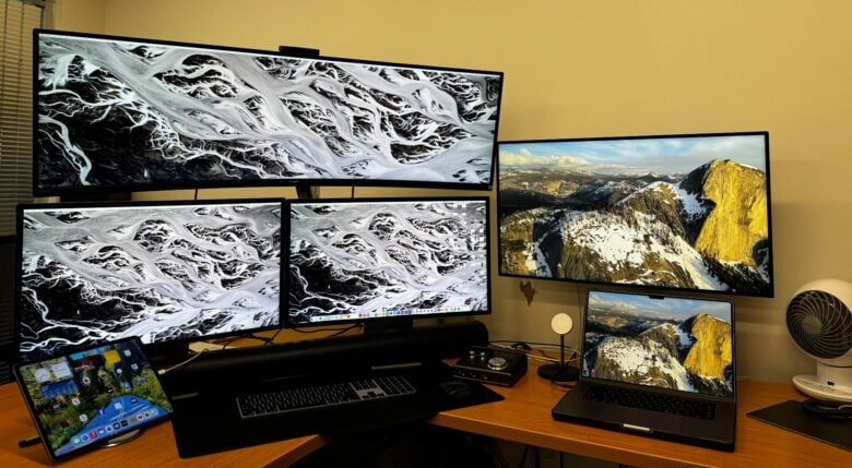 5-display Mac Studio and MacBook Pro setup with Sonos home-theater sound.