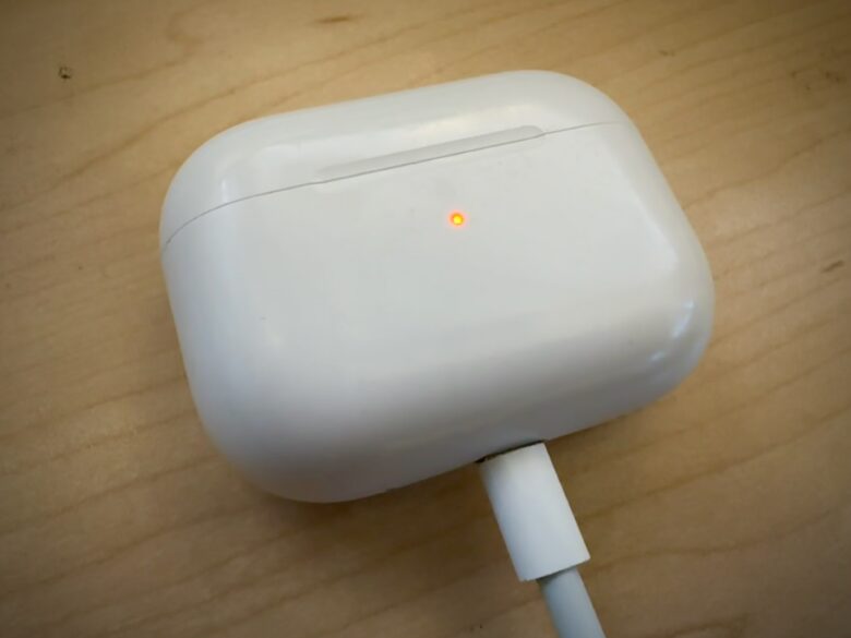 An AirPods case plugged into a charging cable.