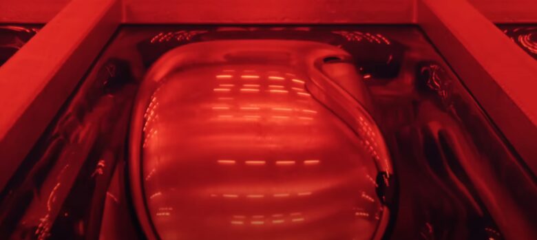 Apple Vision Pro bathed in red light emerging from liquid