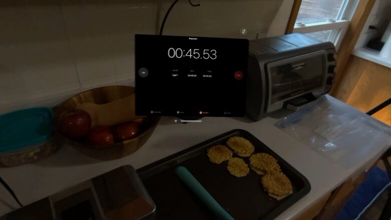 Stopwatch showing 45 seconds, sitting over a pizzelle press and a tray of cooling cookies.