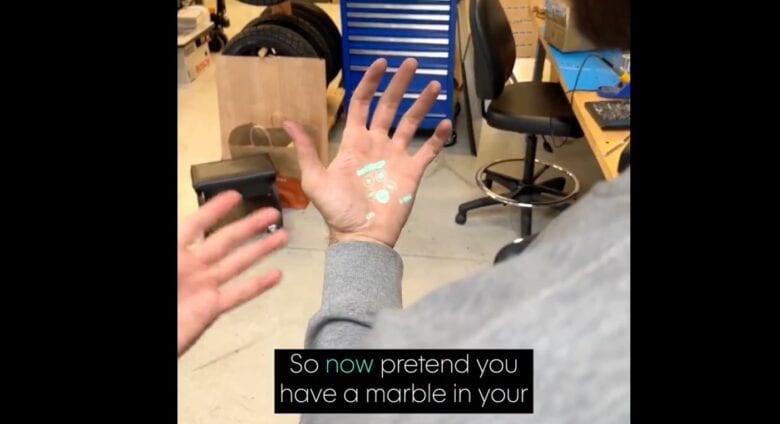 Humane's Home view laser-projected onto the user's hand.