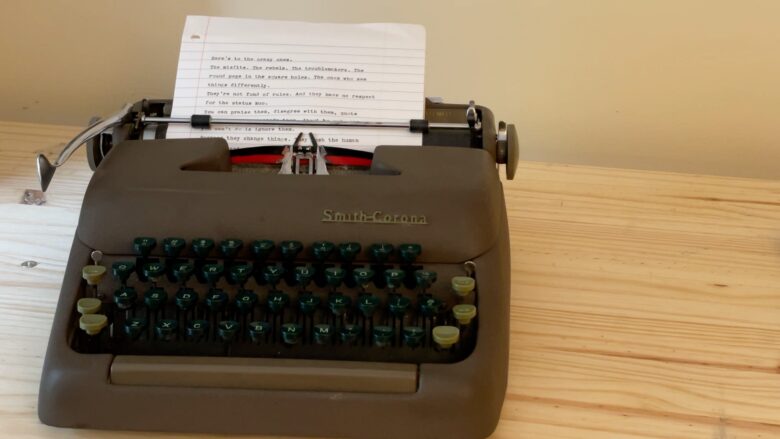 Smith-Corona typewriter with a piece of notebook paper typing the “Here’s to the crazy ones” poem