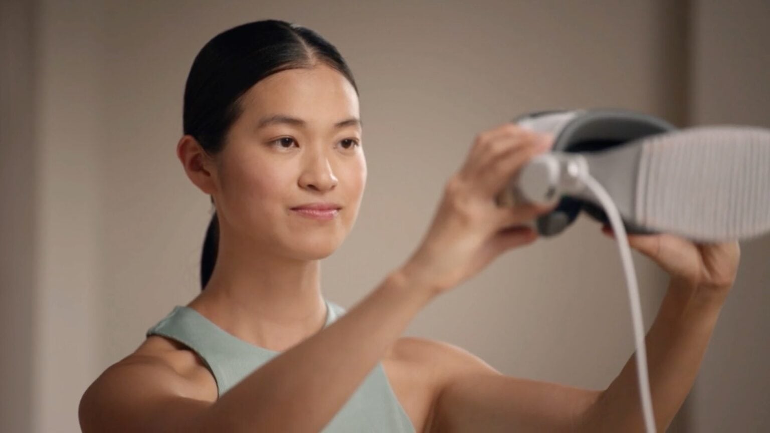 Woman holding a Vision Pro in front of her face, capturing her Vision Pro Persona