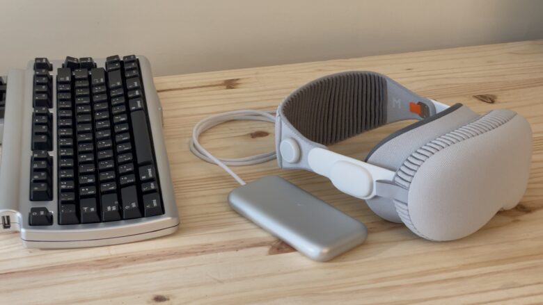 Vision Pro sitting on a pine table next to a Bluetooth keyboard