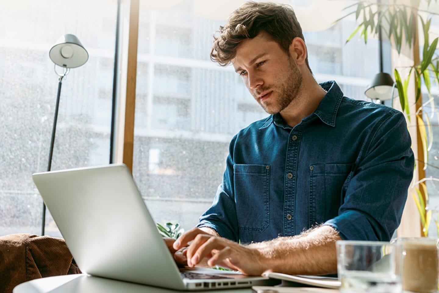 Photo of a man working on a laptop protected by Norton 360 antivirus software.
